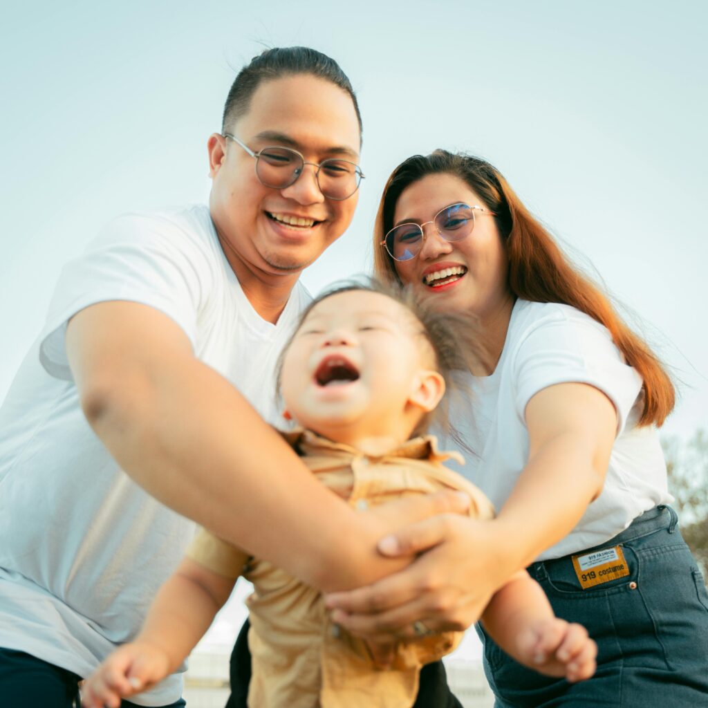 A joyful family scene featuring parents and child enjoying a sunny day outdoors, capturing genuine smiles.