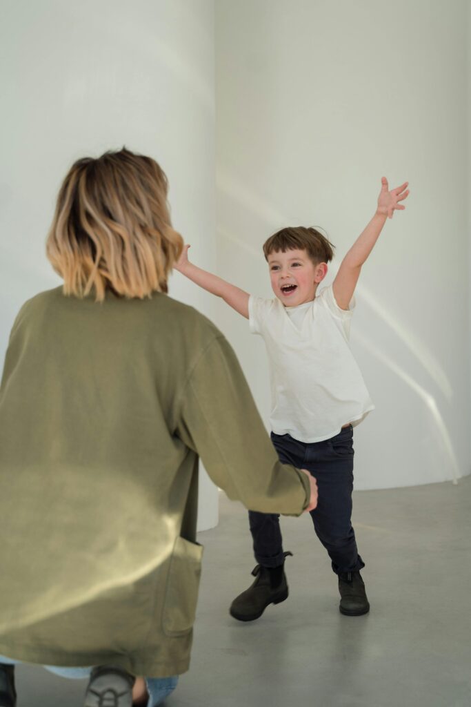 Joyful mother and son playing indoors, embracing happiness and togetherness.
